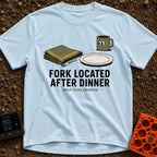 Fork Found Too Late - T-Shirt in Chambray - A cartoon illustration showing a fork partially hidden under a folded green...