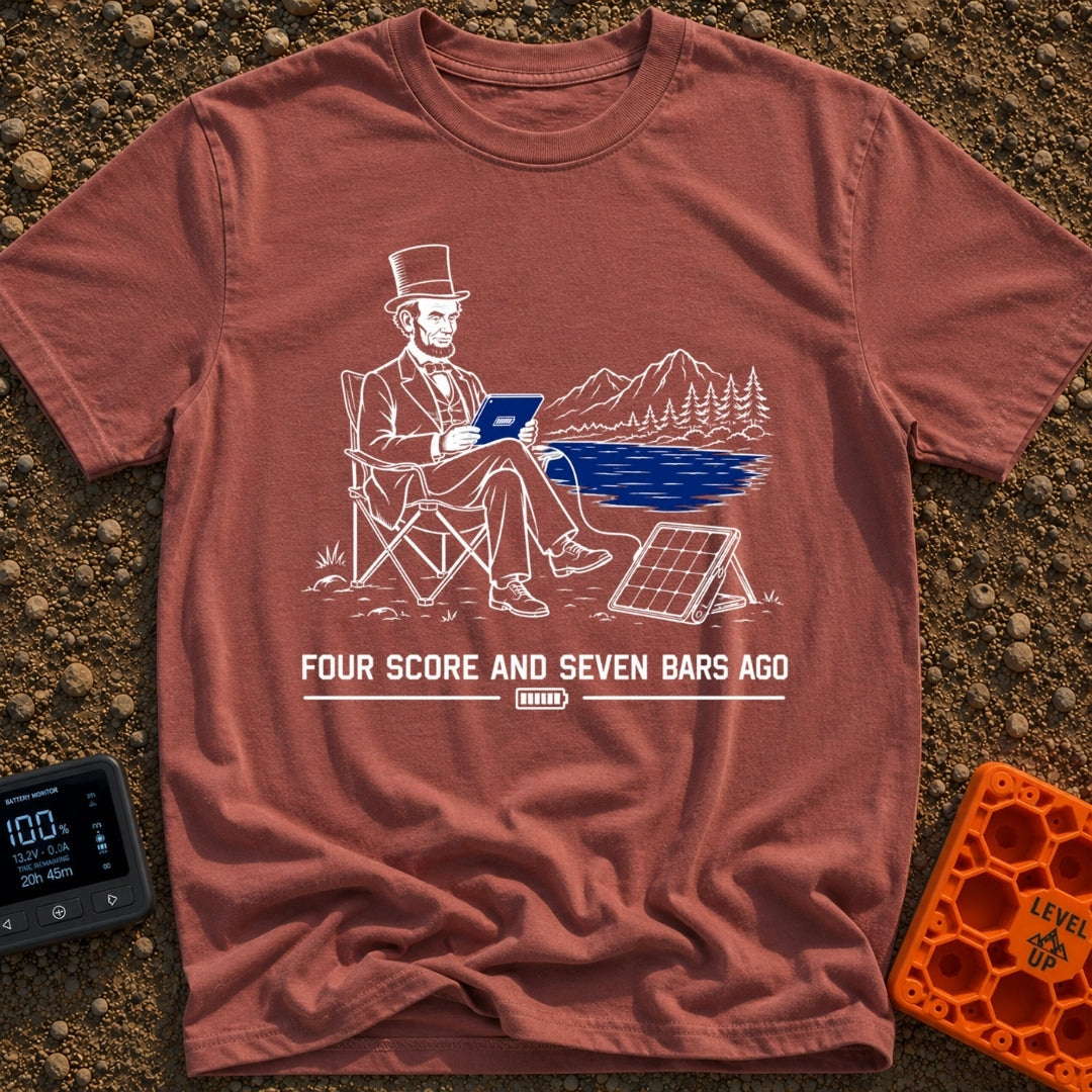 Lincoln Unplugged Adventure - T-Shirt in Brick - A line drawing of Abraham Lincoln sitting in a folding camp chair by a...