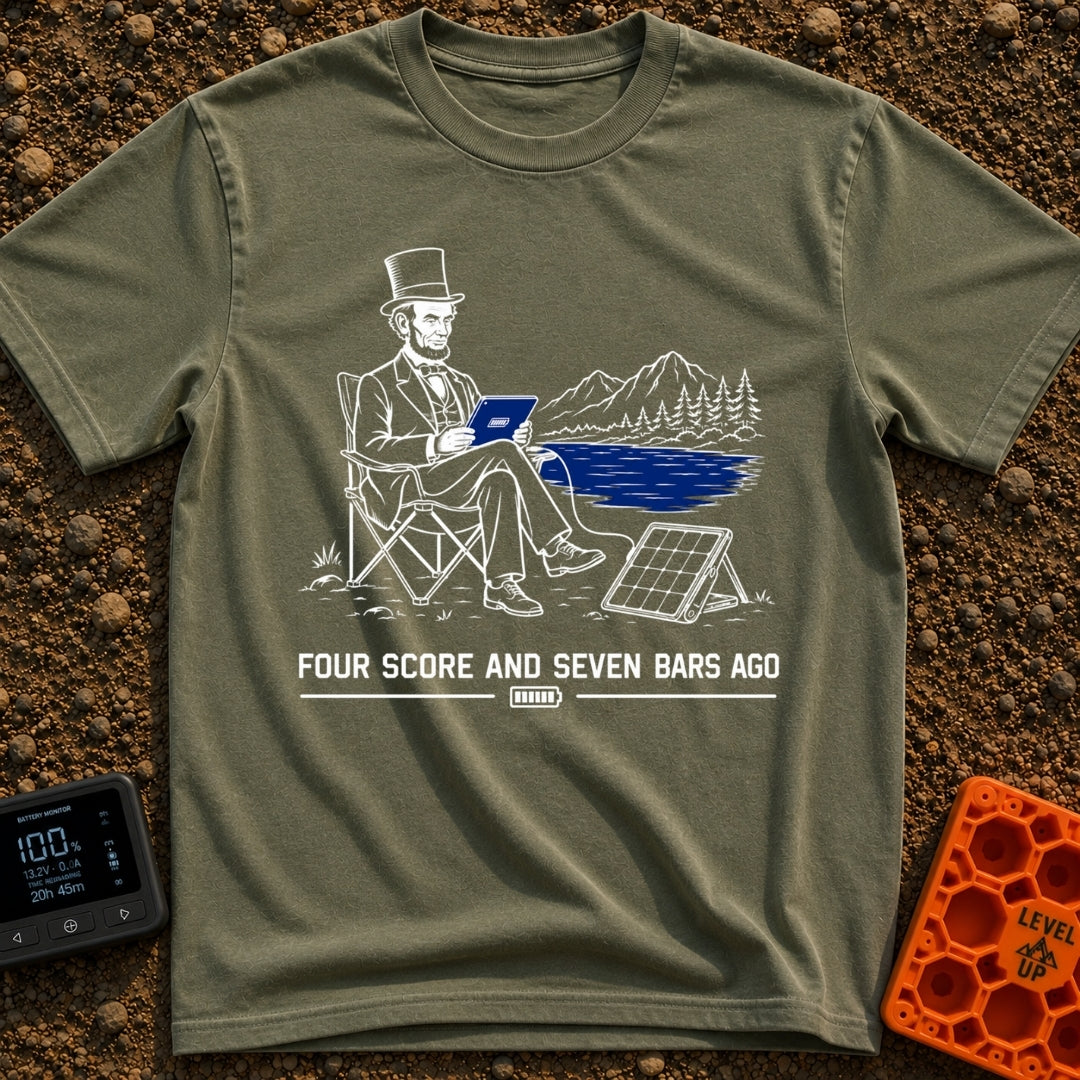 Lincoln Unplugged Adventure - T-Shirt in Moss - A line drawing of Abraham Lincoln sitting in a folding camp chair by a...