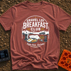 Gravel Gourmet Gathering - T-Shirt in Brick - A camping breakfast setup featuring a Moka pot, a pan of eggs and bacon, a...