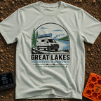 Canoe Venture Vibes - T-Shirt in Bay - A white camper van with a blue canoe strapped to its roof is parked on a gravel...