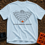 Canyon Wide Web - T-Shirt in Chambray - A black-and-white line drawing of a camper van parked on the rim of a deep,...