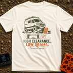 High Clearance Low Drama - T-Shirt in Ivory - A lifted camper van is shown driving over rocks next to two orange vehicle...