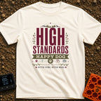 High Standards Happy Dog - T-Shirt in Ivory - A typographic design featuring the text "HIGH STANDARDS HAPPY DOG" and...