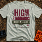 Elevated Adventure Standards - T-Shirt in Bay - A typographic design featuring the text "HIGH STANDARDS HIGHER CLEARANCE"...