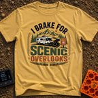 I Brake For Overlooks - T-Shirt in Mustard - A Class C motorhome drives along a winding paved road next to a brown...