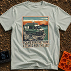 Stayed For The 5G - T-Shirt in Bay - A green camper van with roof-mounted solar panels and a satellite dish is parked on...