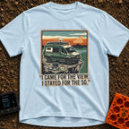 Stayed For The 5G - T-Shirt in Chambray - A green camper van with roof-mounted solar panels and a satellite dish is...