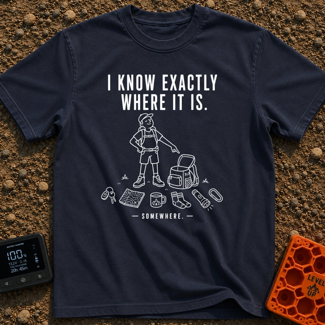 I Know It's Here - T-Shirt in Navy - A white line drawing of a person in a cap and shorts pointing at an open backpack,...