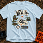 Chase The Sun - T-Shirt in Chambray - A white camper van parked in a sunny clearing with a portable solar panel set up,...