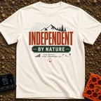 Independent By Nature - T-Shirt in Ivory - A graphic design featuring mountain peaks, pine trees, and topographical map...