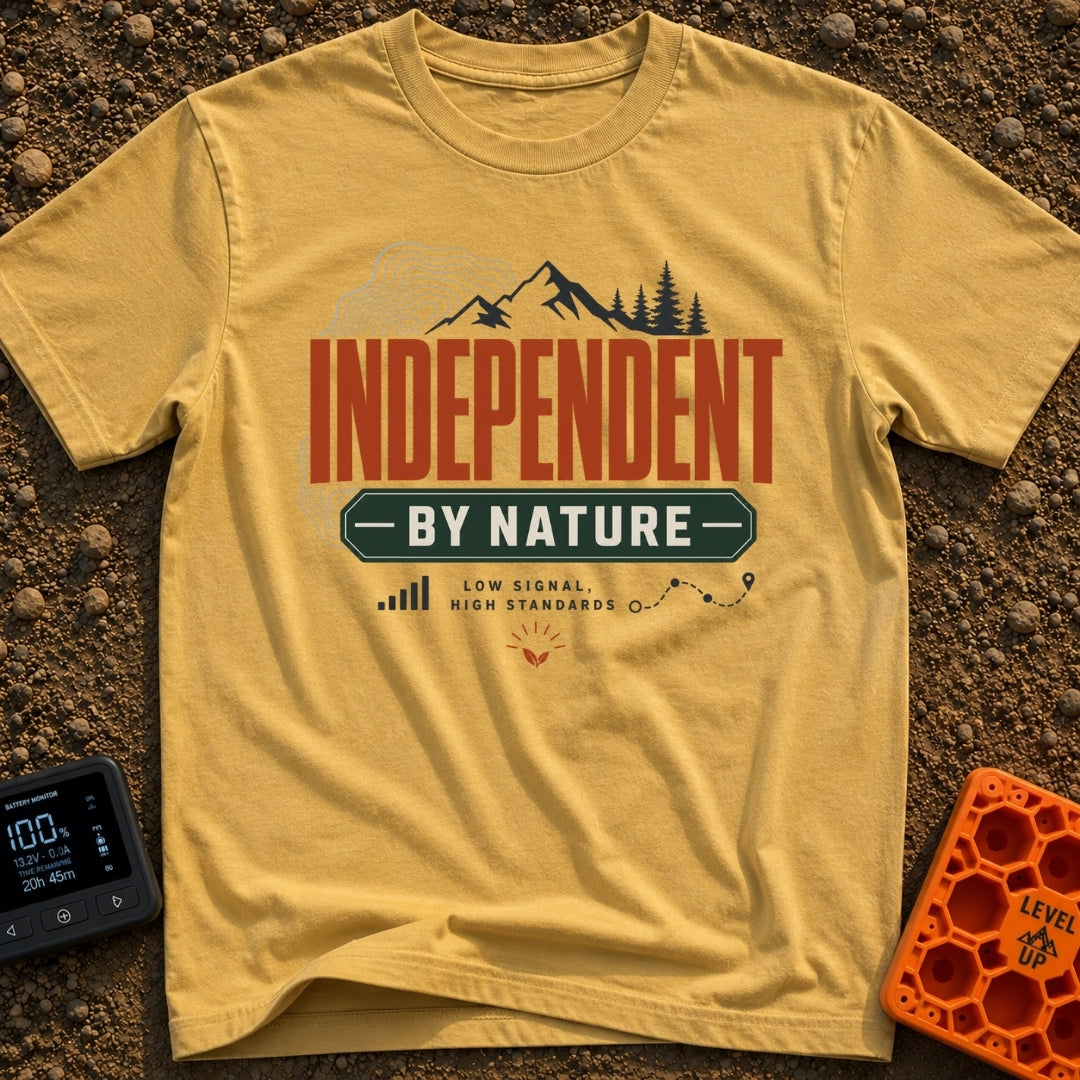 Independent By Nature - T-Shirt in Mustard - A graphic design featuring mountain peaks, pine trees, and topographical map...