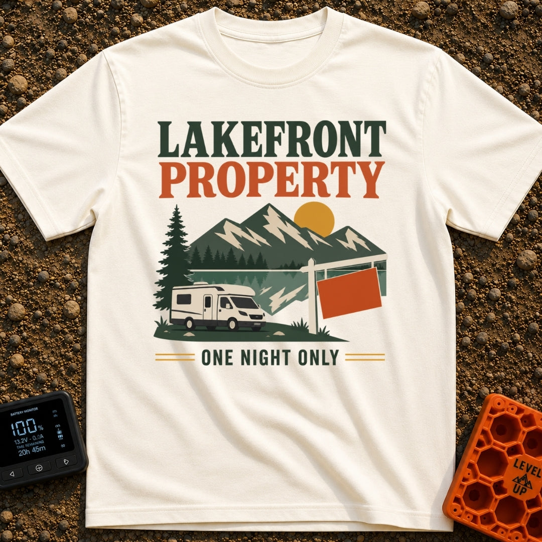 Overnight Lakefront Property - T-Shirt in Ivory - A graphic of a Class C motorhome parked next to a lake, pine trees, and...