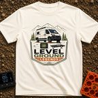 Level Ground Legends - T-Shirt in Ivory - A white camper van parked on orange leveling blocks in front of mountains and...