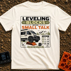 Leveling Before Small Talk - T-Shirt in Ivory - A graphic featuring a camper van parked with its front wheel on an orange...