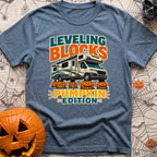 Pumpkin Spice Leveling - T-Shirt in Blue Jean - A graphic showing a Class C motorhome parked with its tires resting on...