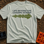 Outside Is Loading - T-Shirt in Bay - The design features the text "LIFE BEYOND THE LOADING SCREEN" above a green graphic...