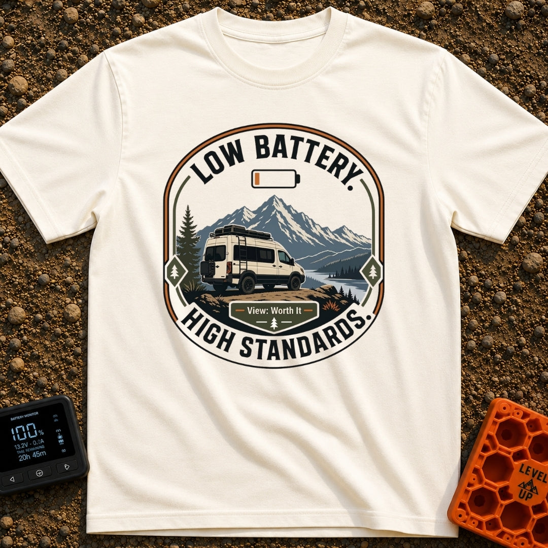 Low Battery High Standards - T-Shirt in Ivory - A badge-style graphic featuring a white camper van parked on a dirt...