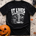 The Mad Roaster - T-Shirt in Black - A white line drawing of a mad scientist using jumper cables attached to a 12-volt...