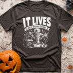 The Mad Roaster - T-Shirt in Graphite - A white line drawing of a mad scientist using jumper cables attached to a 12-volt...