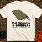 Boundary Mat Mischief - T-Shirt in Ivory - An illustration of an olive green quilted camping mat lying on dirt and grass,...