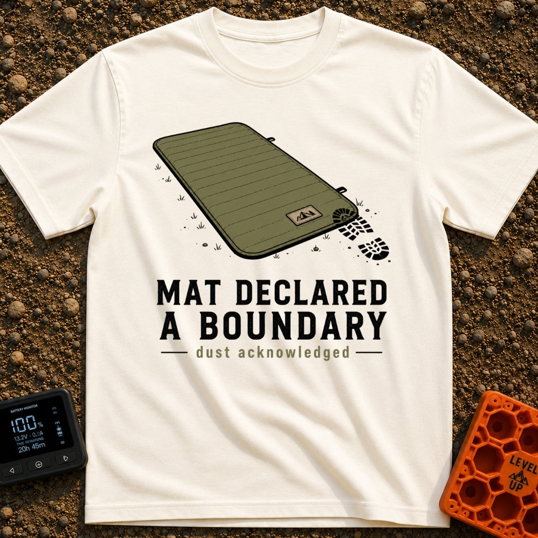 Boundary Mat Mischief - T-Shirt in Ivory - An illustration of an olive green quilted camping mat lying on dirt and grass,...