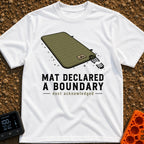 Boundary Mat Mischief - T-Shirt in White - An illustration of an olive green quilted camping mat lying on dirt and grass,...