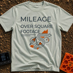 Miles Over Square Feet - T-Shirt in Bay - The design features the text "MILEAGE OVER SQUARE FOOTAGE" above a line-art...