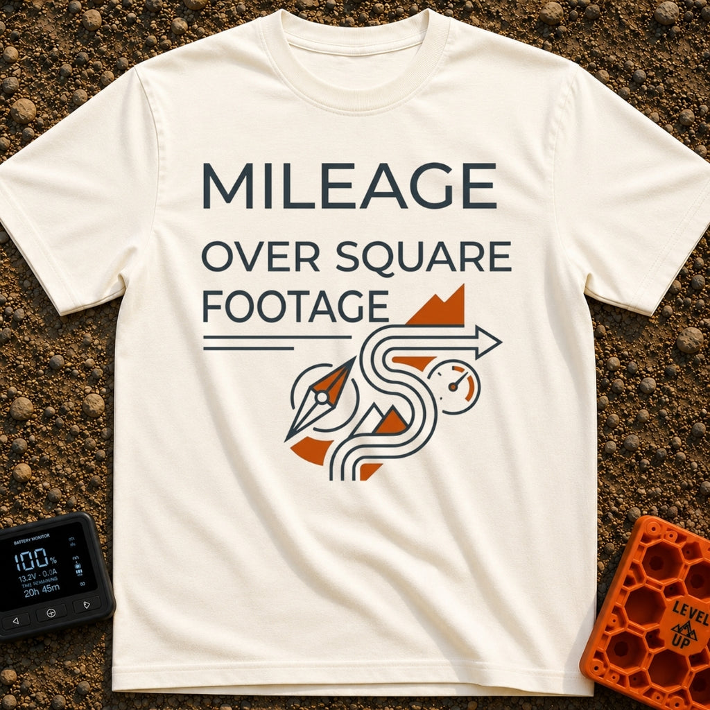 Miles Over Square Feet - T-Shirt in Ivory - The design features the text "MILEAGE OVER SQUARE FOOTAGE" above a line-art...