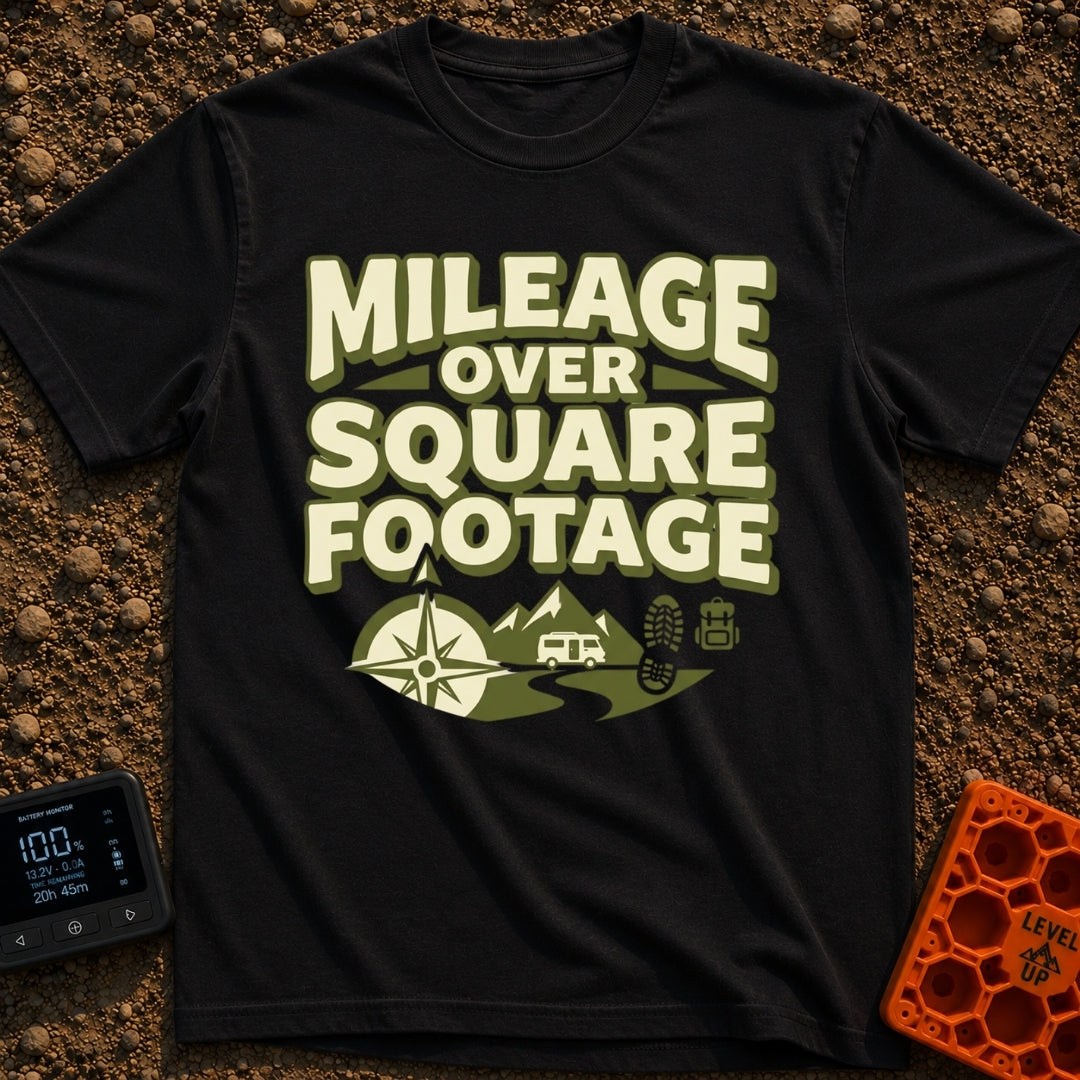 Miles Over Space - T-Shirt in Black - The design features the text "MILEAGE OVER SQUARE FOOTAGE" stacked above a scene...