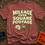Miles Over Space - T-Shirt in Brick - The design features the text "MILEAGE OVER SQUARE FOOTAGE" stacked above a scene...