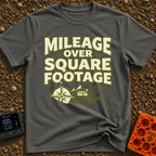 Miles Over Space - T-Shirt in Pepper - The design features the text "MILEAGE OVER SQUARE FOOTAGE" stacked above a scene...