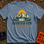 Peak View Upgrade - T-Shirt in Blue Jean - A graphical illustration of a Class C motorhome parked in front of a pine...