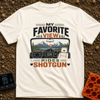 Front Seat Views - T-Shirt in Ivory - A view from inside a vehicle looking out the windshield at a road leading to...