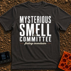 Mysterious Smell Commit - T-Shirt in Graphite - The design features the text "MYSTERIOUS SMELL COMMITTEE" in large block...
