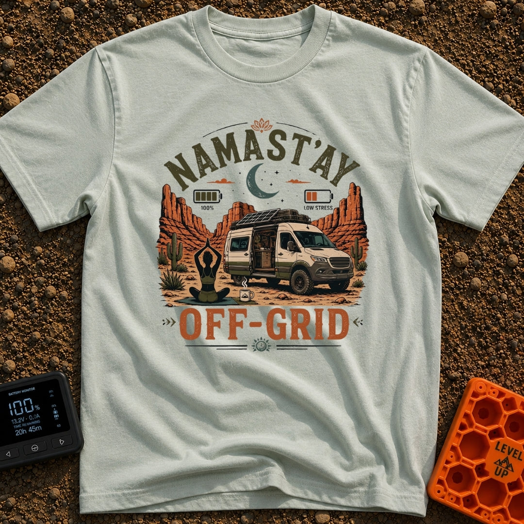 Namastay Off Grid - T-Shirt in Bay - A person is sitting cross-legged on a yoga mat beside a steaming mug of coffee,...