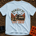 Namastay Off Grid - T-Shirt in Chambray - A person is sitting cross-legged on a yoga mat beside a steaming mug of coffee,...
