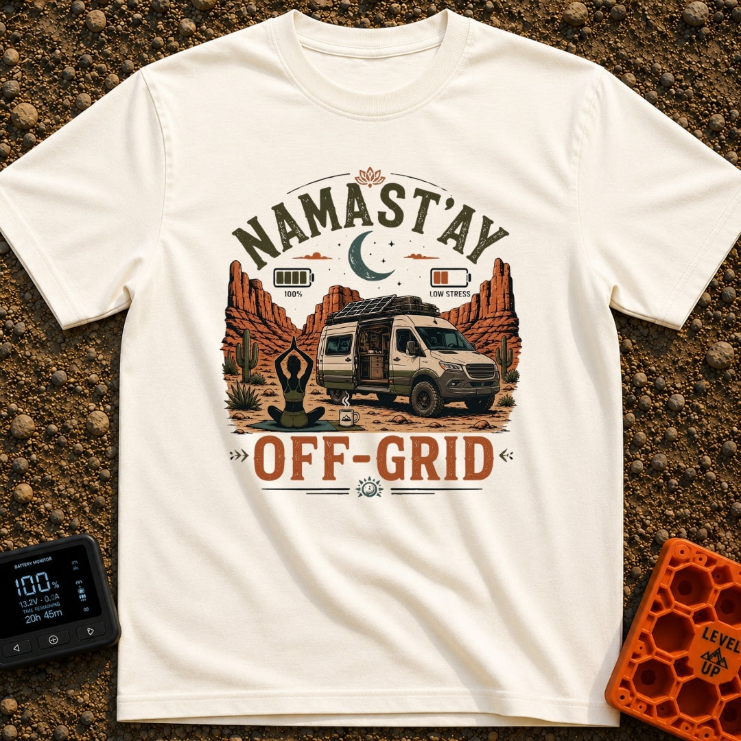 Namastay Off Grid - T-Shirt in Ivory - A person is sitting cross-legged on a yoga mat beside a steaming mug of coffee,...