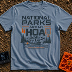 Nature Is My HOA - T-Shirt in Blue Jean - A graphic of a fifth-wheel RV parked in front of a mountain range and pine...