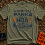 Nature Is My HOA - T-Shirt in Moss - A graphic of a fifth-wheel RV parked in front of a mountain range and pine trees....