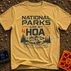 Nature Is My HOA - T-Shirt in Mustard - A graphic of a fifth-wheel RV parked in front of a mountain range and pine trees....