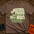 Nature Is My HOA - T-Shirt in Espresso - A graphic featuring a Class A motorhome parked in front of pine trees,...