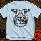 Parks Are My HOA - T-Shirt in Chambray - A graphic emblem featuring a Class C motorhome parked in front of mountains and...