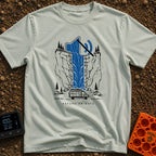 Stream On Mute - T-Shirt in Bay - An illustration of a camper van parked at the base of a steep cliff with pine trees,...