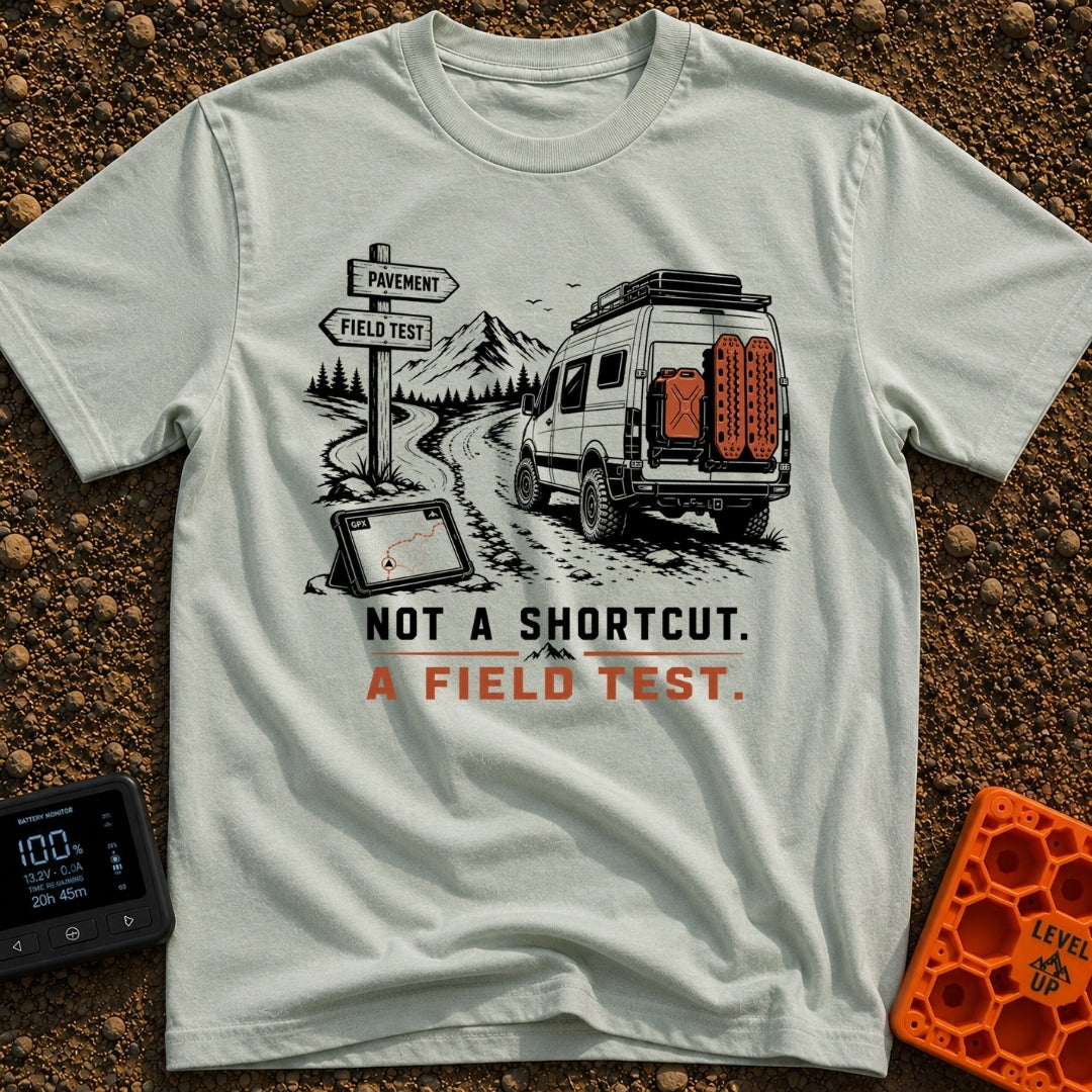 Just A Field Test - T-Shirt in Bay - An illustration of an off-road equipped camper van with recovery boards driving on a...