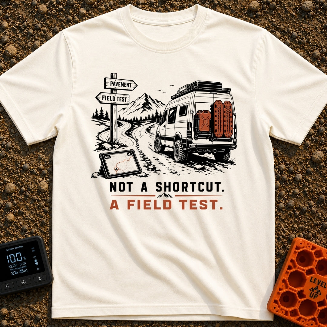 Just A Field Test - T-Shirt in Ivory - An illustration of an off-road equipped camper van with recovery boards driving on...