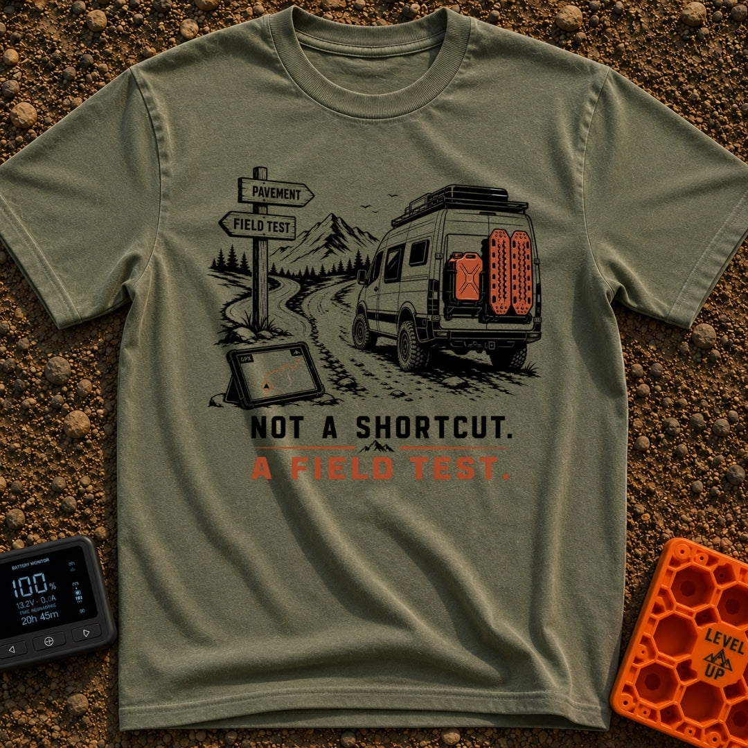 Just A Field Test - T-Shirt in Moss - An illustration of an off-road equipped camper van with recovery boards driving on...