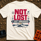 Unmanaged On Purpose - T-Shirt in Ivory - Large text reading "NOT LOST JUST UNMANAGED" alongside icons of a compass, low...