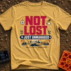 Unmanaged On Purpose - T-Shirt in Mustard - Large text reading "NOT LOST JUST UNMANAGED" alongside icons of a compass,...