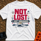 Unmanaged On Purpose - T-Shirt in White - Large text reading "NOT LOST JUST UNMANAGED" alongside icons of a compass, low...